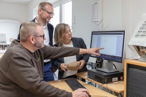 Mitarbeiter von NEXTPACK zeigen Kundin die fertig entwickelte Verpackung am Bildschirm