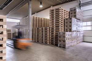 Lagerhalle von NEXTPACK, in welcher gestapelte Transportbehälter zu sehen sind